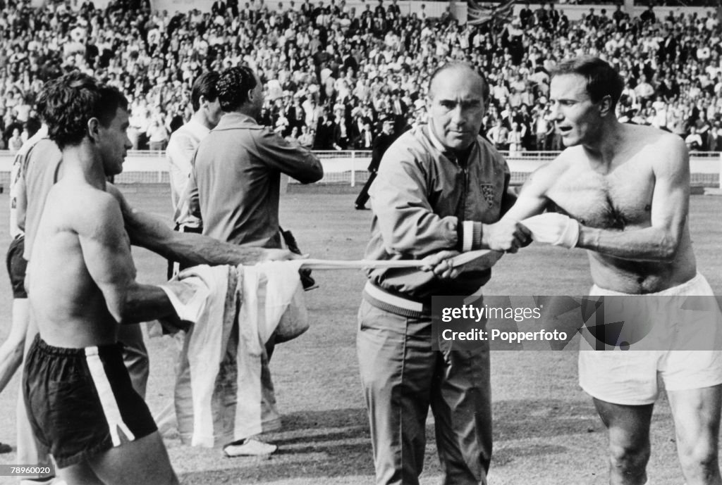 Sport. Football. pic: 23rd July 1966. 1966 World Cup Finals. World Cup Semi-Final. England 1 v Argentina 0. Wembley. England Manager Alf Ramsey, does his best to stop defender George Cohen, right, swapping shirts with Argentina's Alberto Gonzalez after wh