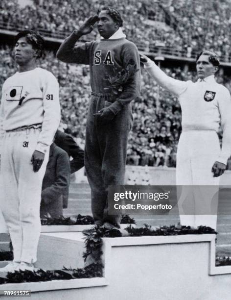 Sport, 1936 Olympic Games in Berlin, Mens Long Jump, Medal Ceremony, USA's Jesse Owens, centre, salutes the flag after winning the Gold medal, with...