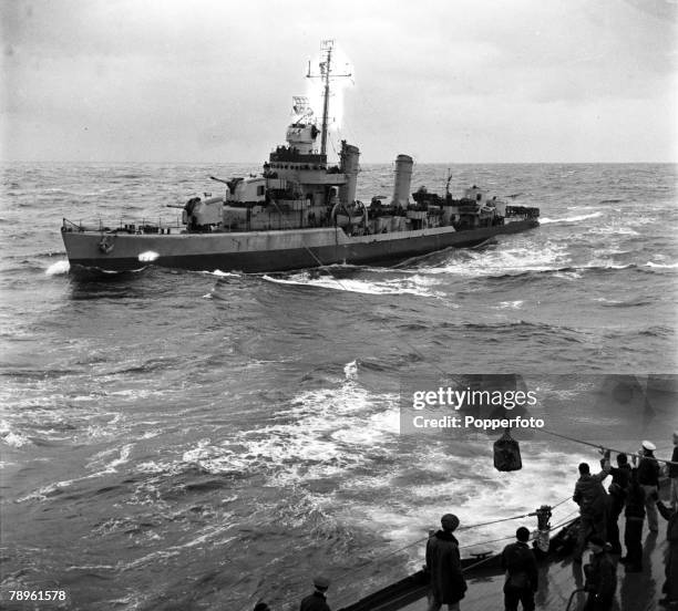 World War II, Atlantic Ocean A package is pictured being sent from the dreadnought battleship USS Arkansas to a destroyer by way of cables linking...