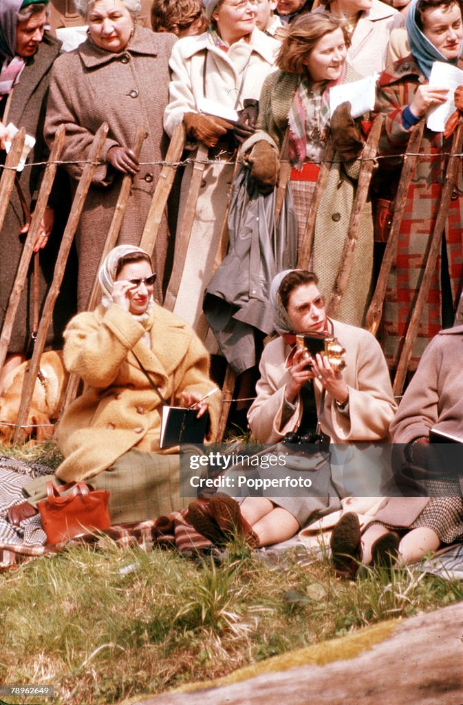 England. 1957. Queen Elizabeth II is pictured taking cine films at the Badminton Horse Trials as she sits with Princess Margaret (left).