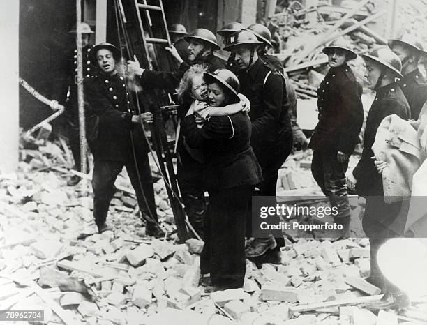 Young child is rescued by an air raid warden from a bombed out house following a German Luftwaffe bombing raid on London during The Blitz in World...