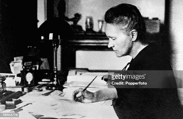 Polish-French physicist Marie Curie working at her desk, circa 1910. Marie Curie won the 1903 Nobel Prize for Physics with husband Pierre and after...