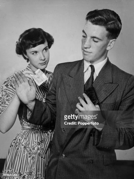 People, Couples, Romance, pic: circa 1950, A young couple in a finance situation, as the man puts his wallet away as the young woman takes the money