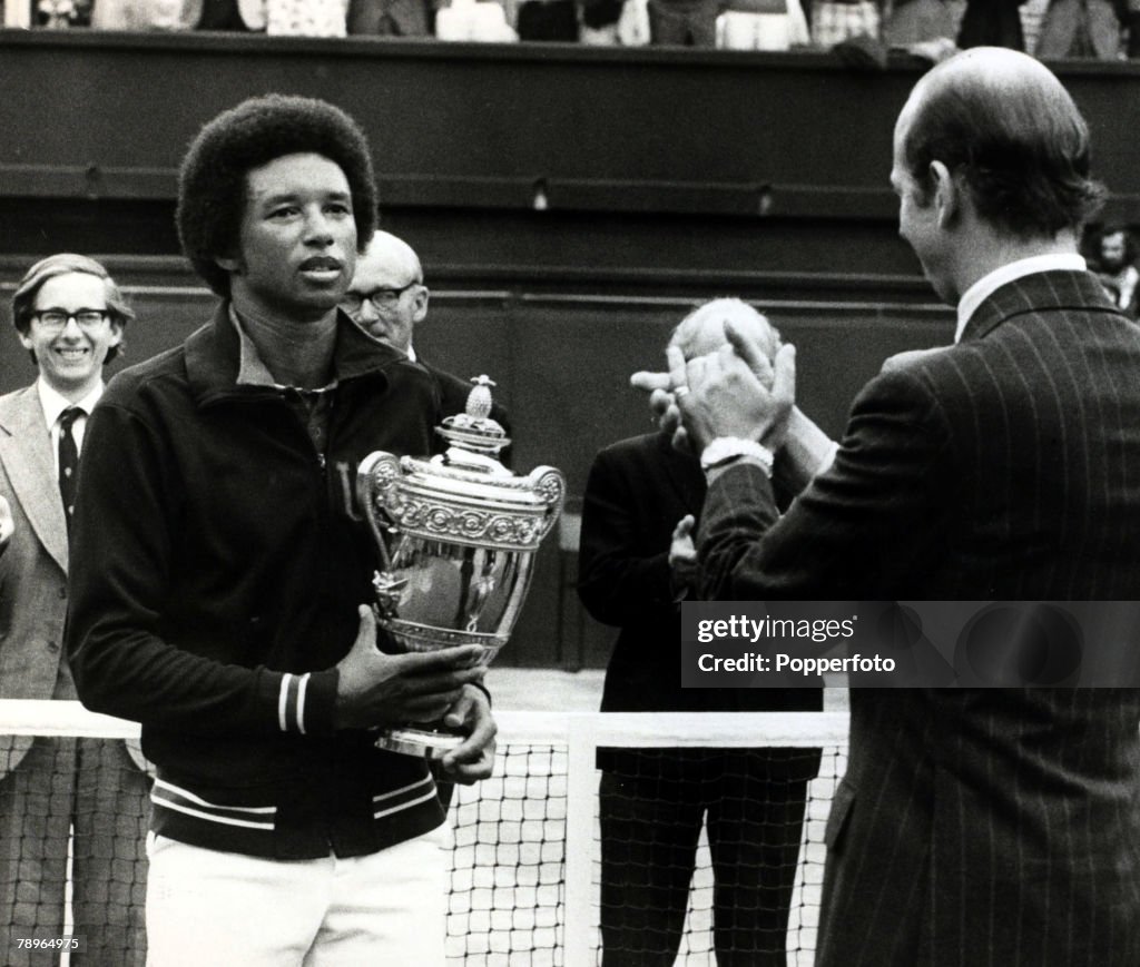 Sport. Tennis. pic: 1975. U.S.A.'s Arthur Ashe, (1943-1993) pictured with the Wimbledon Mens Singles Championship trophy after beating Jimmy Connors in the Final, with H.R.H. Duke of Kent joining in the applause. Arthur Ashe was the first African-American