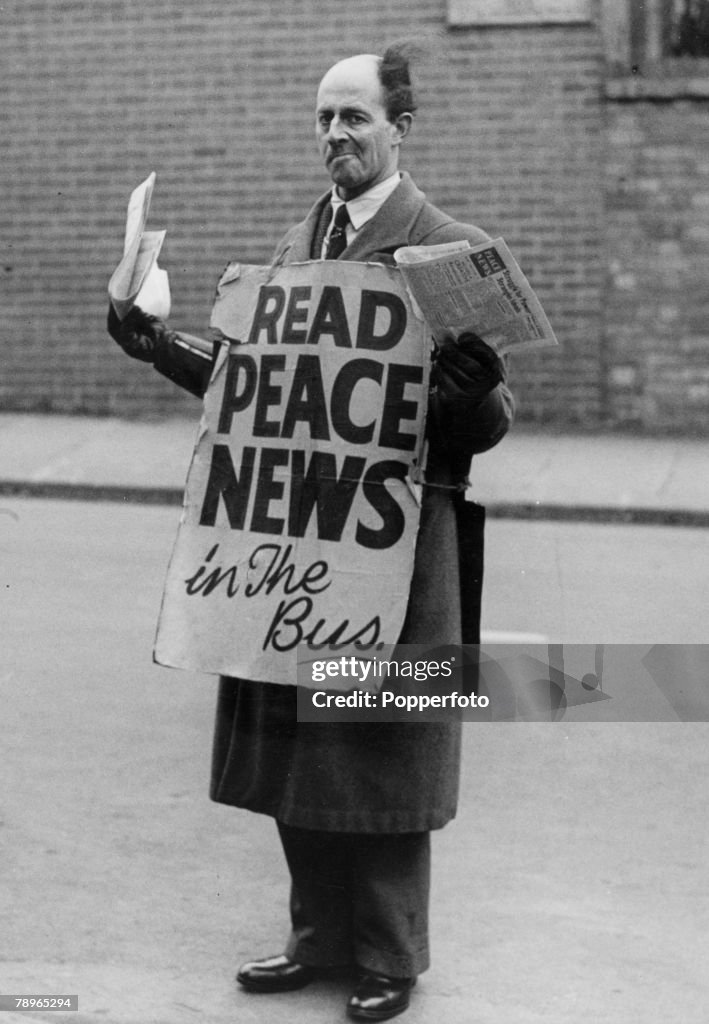 Social History. War and Conflict. World War Two. pic: circa 1943. Northampton, Northamptonshire, England. Stanley Seamark, a pacifist, pictured outside the Bus Station in Derngate, Northampton, offering the "Peace News" to bus travellers.