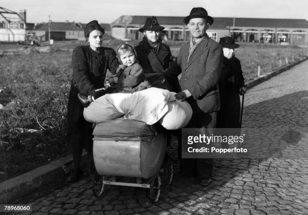 War and Conflict, World War Two, pic: October 1944, Aachen, Germany, A German family, their belongings piled on a pram, are evacuated from the...