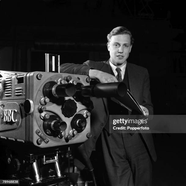 Portrait of British naturalist and broadcaster David Attenborough posed beside a BBC television camera at a television studio in London in March...