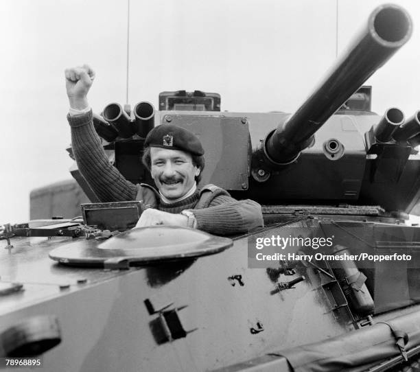 Liverpool FC footballer Tommy Smith posing in army uniform on board a tank on May 10, 1977 in Liverpool, England.