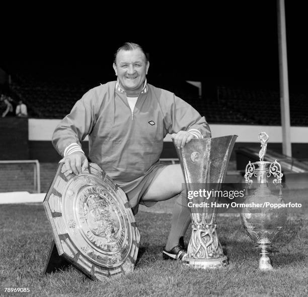 Liverpool FC manager Bob Paisley posing with the Charity Shield, UEFA Cup and League Championship trophies at Anfield in Liverpool, England, circa...