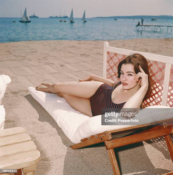 Christine Keeler, key figure in the 1963 Profumo Scandal which rocked the government, wearing a swimsuit as she relaxes on a sun lounger, 1963