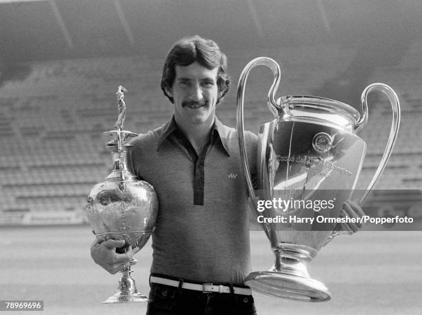 Liverpool FC footballer Terry McDermott with the League Championship and European Cup trophies at Anfield in Liverpool, England, circa October 1977.