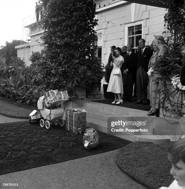 New Zealand, 24th December Queen Elizabeth II using her cine camera at Government House, watched by Prince Philip, Duke of Edinburgh, to film Santa...