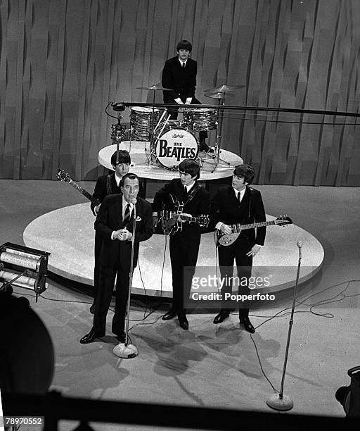 Elevated view of American television personality Ed Sullivan , with the members of British Rock group the Beatles, during an episode of 'The Ed...