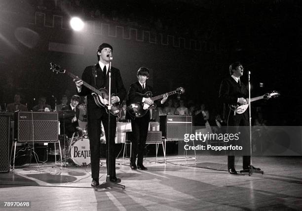 The Beatles pop group, performing live on stage at a concert in 1963