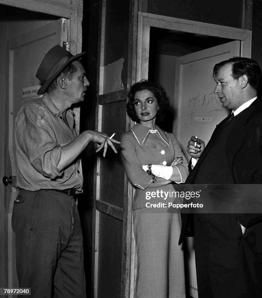 Actors Elizabeth Sellars and Peter Finch speaking with film director Leslie Norman during the making of the film "The Shiralee" at Ealing Studios,...