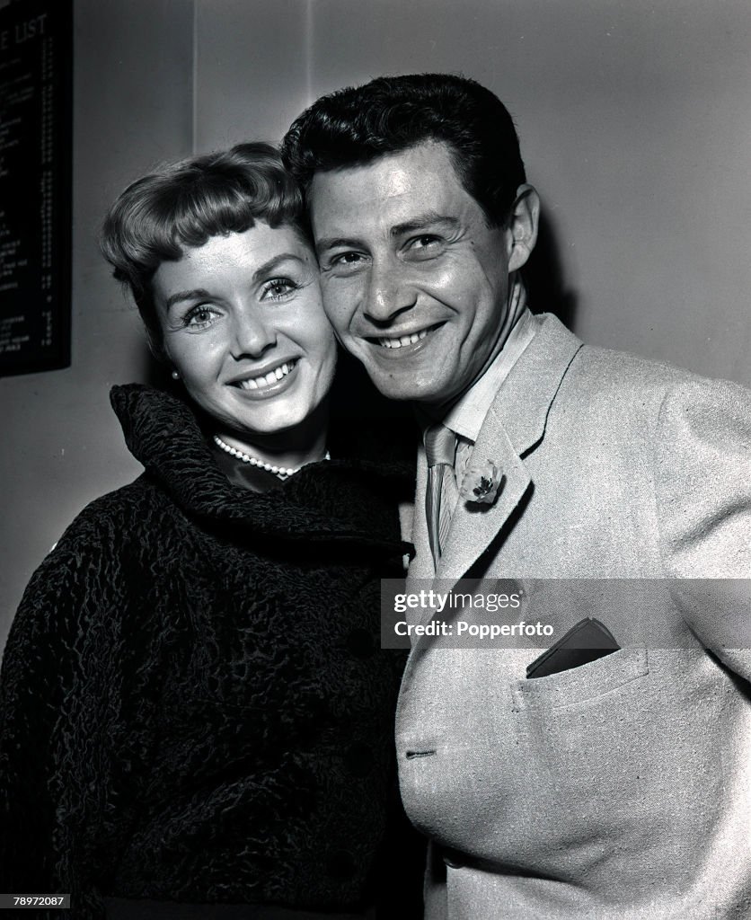 American singer Eddie Fisher with his actress wife Debbie Reynolds in London, both smiling, 1957.