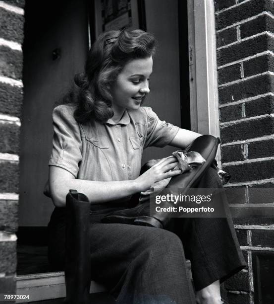 Film actress Jean Simmons polishing and cleaning her riding boots, 28th February, 1946