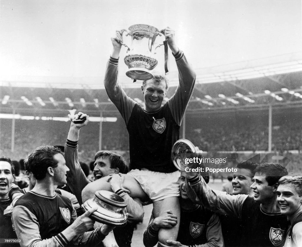 Football. 2nd May 1964. Wembley Stadium, London. FA Cup Final. West Ham United 3 v Preston North End 2. West Ham United captain Bobby Moore holds aloft the FA Cup as he is chaired by his teammates after their victory.