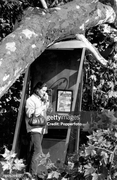 17th October 1987, Britain recovers from its worst storm in 300 years, Picture shows a woman who has found a telephone box still in working order...
