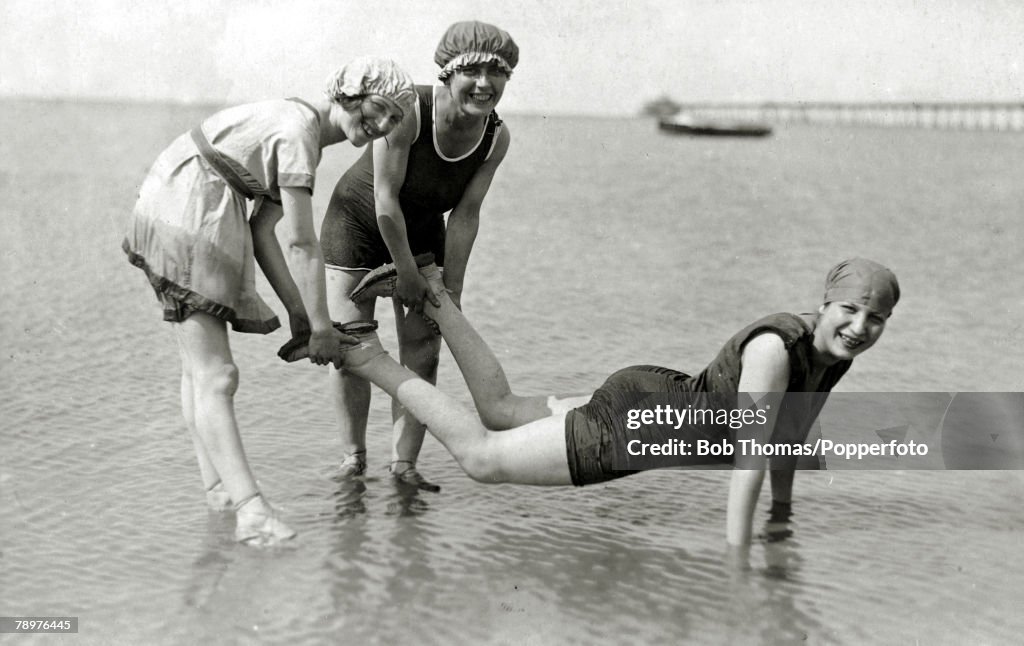People. Holidays. pic: August 1921. England, Herne Bay. Three young women in bathing suits enjoying themselves in the sea.