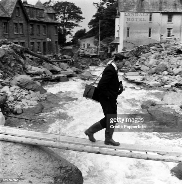 Lynmouth floods Pressmen had a hazardous job in getting around the devastation, bridges were very temporary and precarious