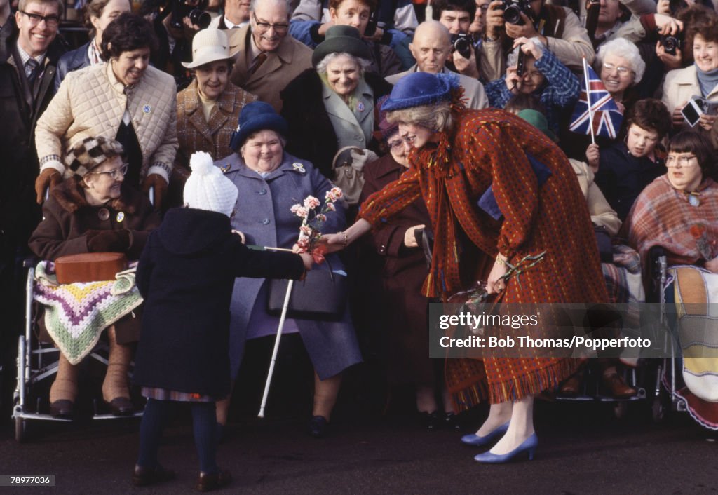 British Royalty. Wrexham, Wales. 26th November 1982. Princess Diana receives a small gift of flowers from a young child while meeting the crowds during a visit to the town.