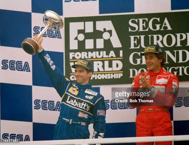 British Formula One racing driver Damon Hill raises the trophy in the air after driving the Canon Williams Renault Williams FW15C Renault RS5 3.5 V10...
