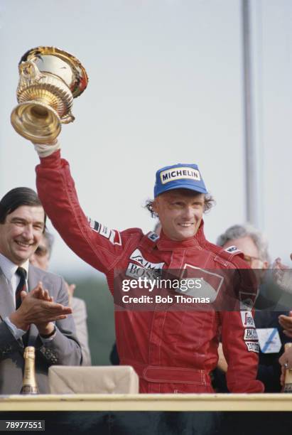 Austrian Formula One racing driver Niki Lauda raises the trophy in the air after driving the Marlboro McLaren International McLaren MP4/2 TAG TTE PO1...