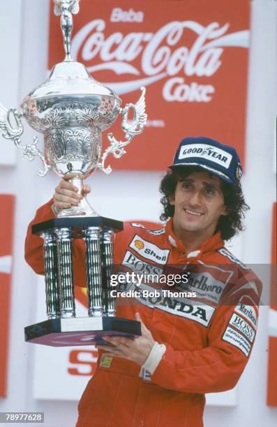 Alain Prost of France, driver of the Honda Marlboro McLaren McLaren MP4/4 Honda V6 t pictured celebrating with the trophy on the podium after...