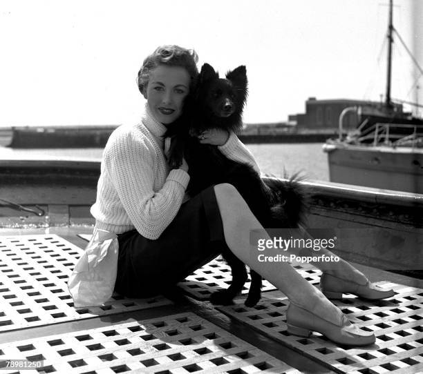 Actress, Hazel Court with a dog on the the ship's deck in between takes of the film "Ghost ship"