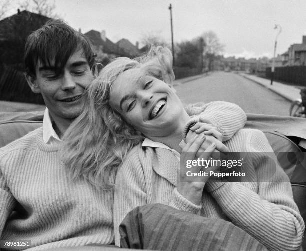 London, England, British film and movie actress Shirley Eaton with her fiancee Colin Lenton-Rowe as they laugh in the back seat of a car