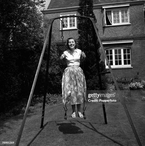 England, A picture of British singer Vera Lynn standing on a swing in her garden