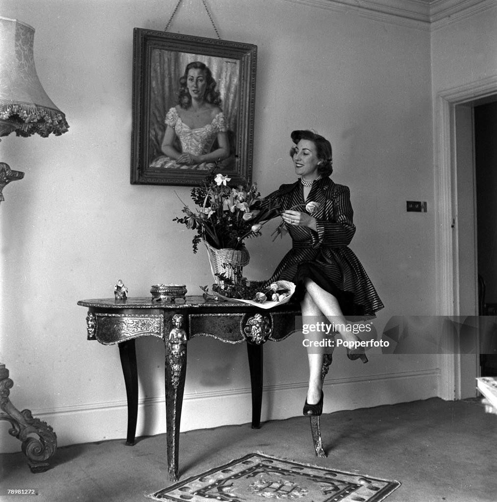 1952. England. British singer Vera Lynn arranges flowers at a table in her home.