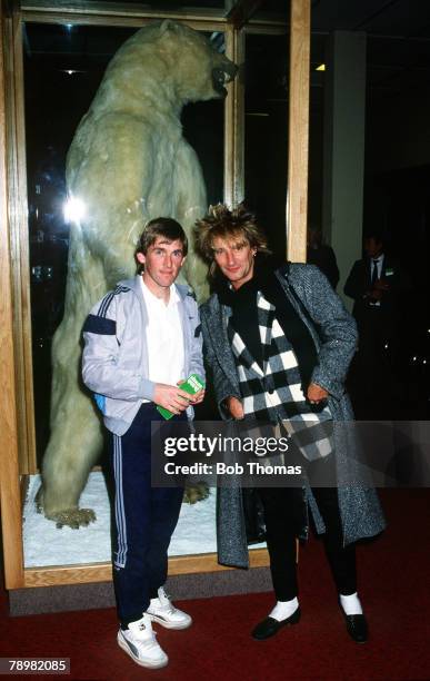 December 1984, Liverpool's Kenny Dalglish meets up with British pop star Rod Stewart at Anchorage Airport as they pose before a huge stuffed polar...