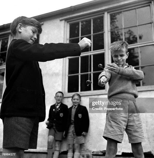 Two young boys play conkers in the school playground