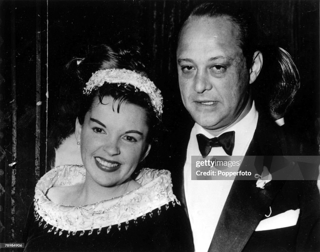 5th February 1956. Santa Monica, California. Singing film star Judy Garland arrives at the Hollywood premiere of her film "A Star is Born" with third husband Sid Luft - against whom she filed for divorce, charging extreme cruelty.