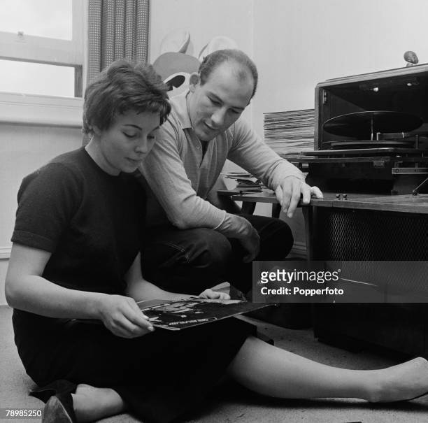 Sport, Motor Racing, England Racing driver Stirling Moss at home with his fiance Katie as they select some musical records to play on their Hi-Fi...