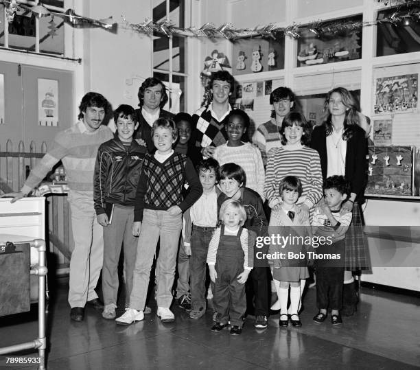 December 1981, Arsenal players left-right, Kenny Sansom, Pat Jennings, David O'Leary and Charlie Nicholas with children at a christmas party at...