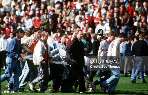 15th April 1989, F.A. Cup Semi-Final at Hillsborough, Liverpool 0,v Nottingham Forest 0, Match Abandoned, An injured fan is carried on an advertising...