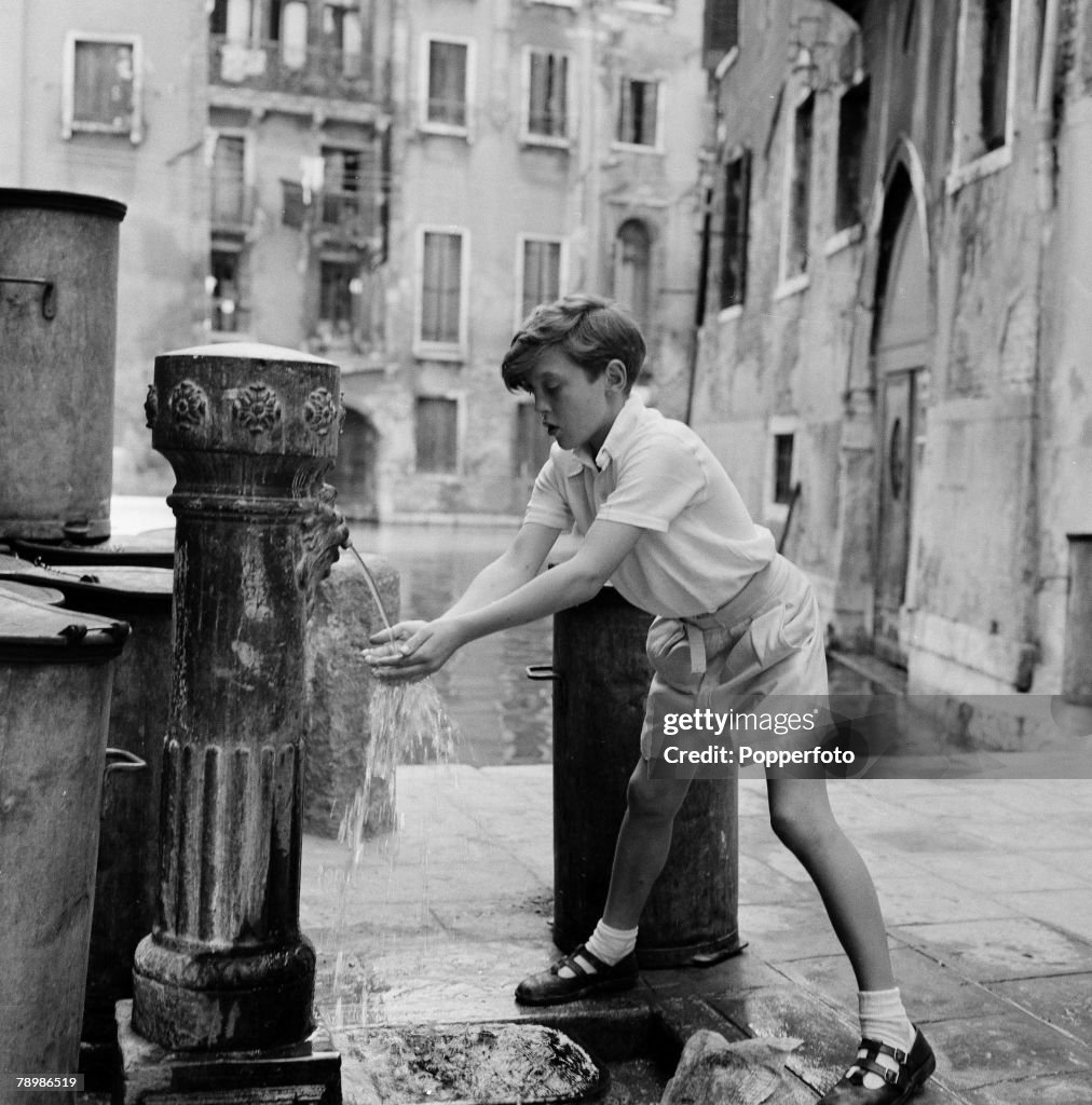 Stage & Screen. Venice, Italy. 1954. Singer David Hemmings, aged 12 enjoying Venice (drinking water from a fountain) between rehearsals of Benjamin Britten's new opera 'Turn of the Screw" in which he sings.