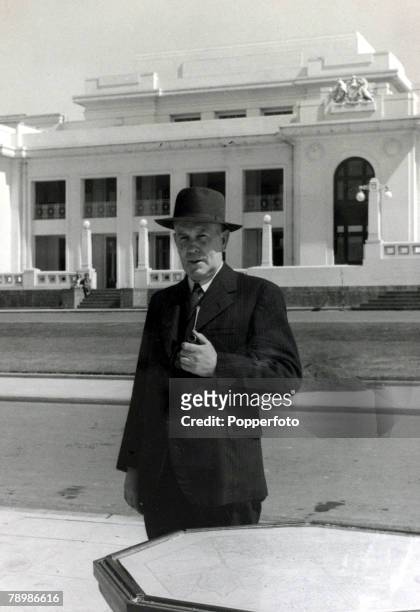 Australian Labour Party politician Ben Chifley , Prime Minister of Australia, stands holding a pipe in front of the Provisional Parliament House in...