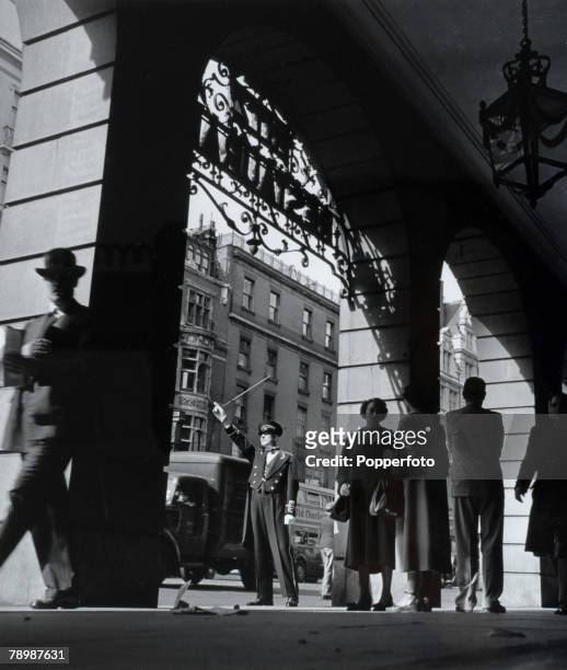 Travel, London, England The Ritz Hotel, The arches of the Hotel facing Piccadilly, with a doorman hailing a taxi for hotel guests