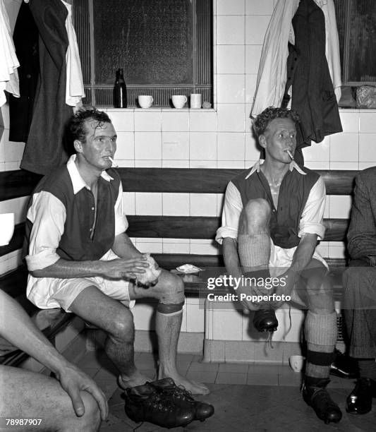 Highbury, London, Arsenal players Walley Barnes, left, and Archie Macauley smoking cigarettes in the Highbury dressing room