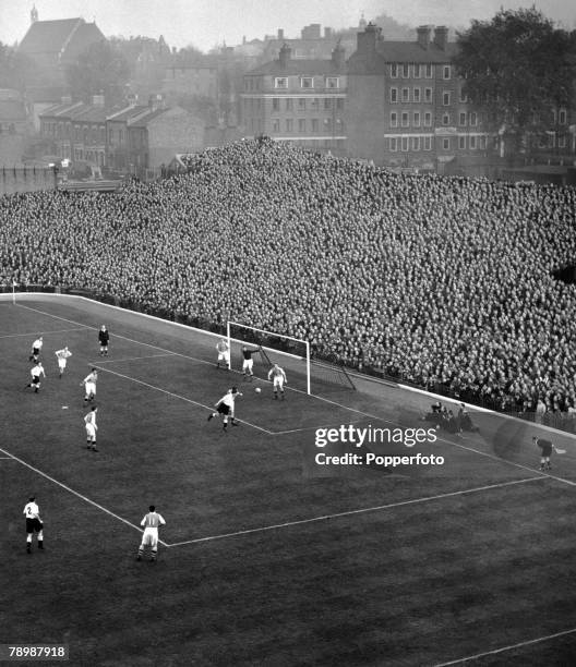 An aerial shot shows action from an Arsenal home match at Highbury Stadium, London, showing a packed terrace at the famous "Clock End"