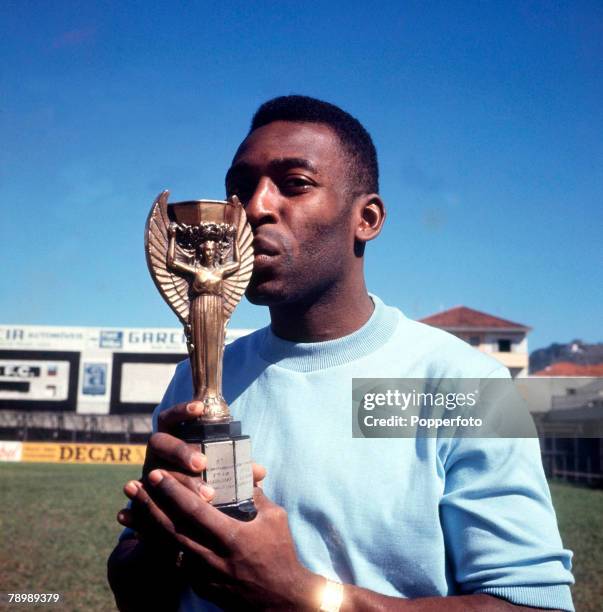 Football, Brazilian legend Pele, one of the stars of the victorious Brazil team of the 1970 World Cup Finals in Mexico, kisses the Jules Rimet trophy...