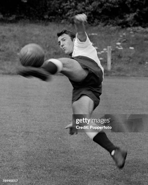 English footballer and striker with Tottenham Hotspur, Jimmy Greaves in mid air kicking a ball during pre season training circa 1962.