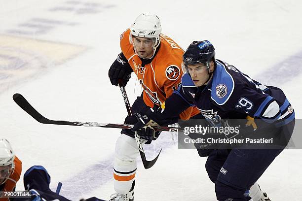 Left wing Jason Pitton of the Bridgeport Sound Tigers and right wing Troy Bodie of the Springfield Falcons during a face off in the first period on...