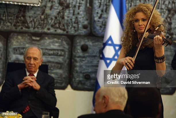 Grammy Award-winning musician Miri Ben-Ari plays "Symphony of Brotherhood" alongside Israeli President Shimon Peres during a ceremony at his official...