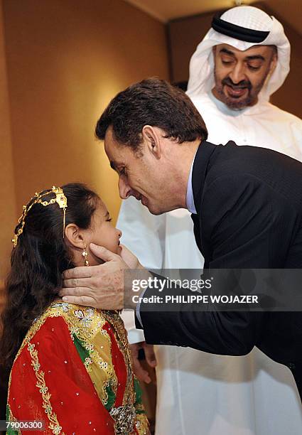 French President Nicolas Sarkozy kisses Princess Hassa as her father Abu Dhabi Crown Prince Sheikh Mohammed Bin Zayed Al Nahyan looks on after a...