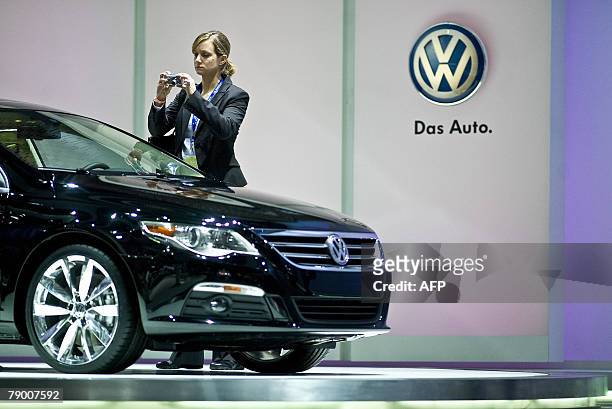 Woman photographs the Volkswagen Passat CC at the 2008 North American International Auto Show in Detroit, Michigan, 15 January 2008. AFP PHOTO/Geoff...